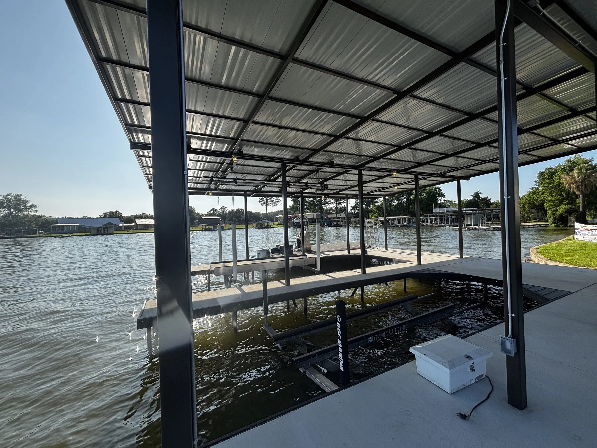 Boat lift in an open slip beside the boathouse storage room